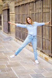 Full length of young woman walking on footpath