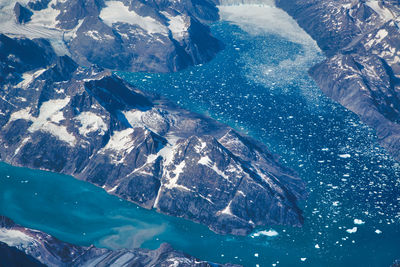 High angle view of snowcapped mountain by sea