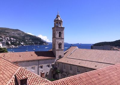 Buildings in town against clear blue sky