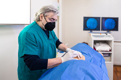 Doctor practices the infiltration of drugs to the patient in the area affected by the pain.