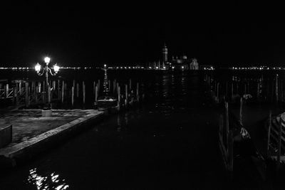 Illuminated water against sky at night