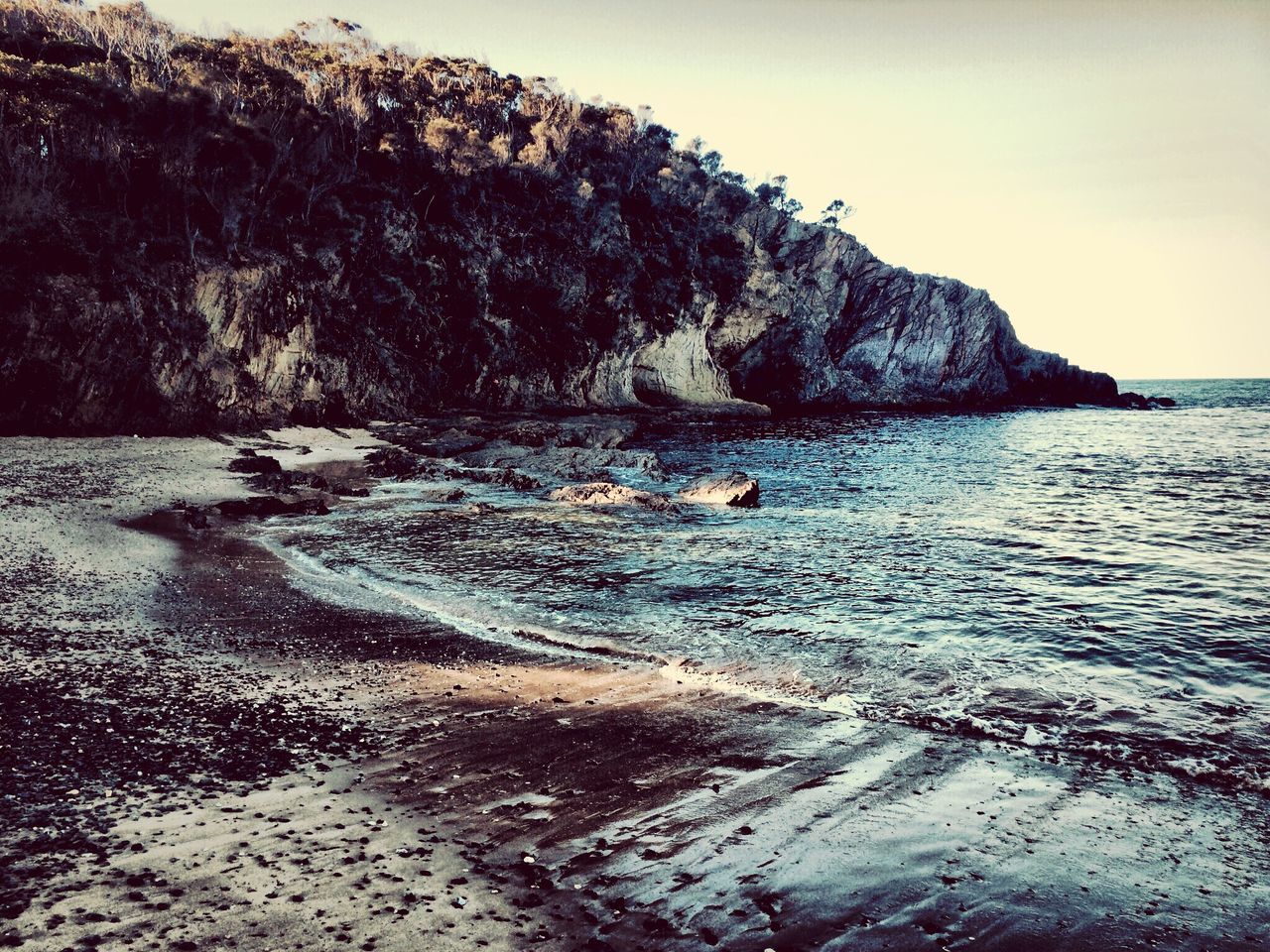 water, sea, tranquil scene, tranquility, scenics, beauty in nature, beach, rock formation, rock - object, nature, shore, sky, cliff, coastline, idyllic, clear sky, rock, horizon over water, mountain, remote