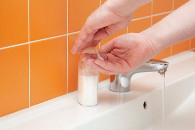 Close-up of hands using soap dispenser