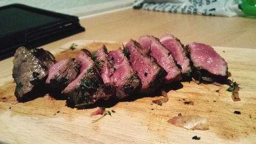 Close-up of roasted red meat on cutting board