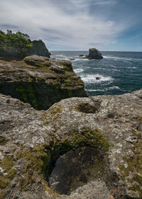 Scenic view of rocks on beach against sky