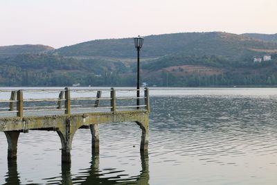 Wooden posts in lake against clear sky