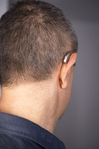 Rear view of man with tattoo against black background