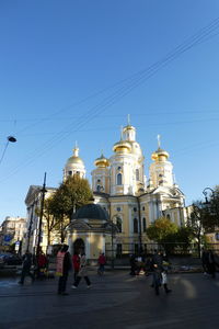 People in front of building against clear sky