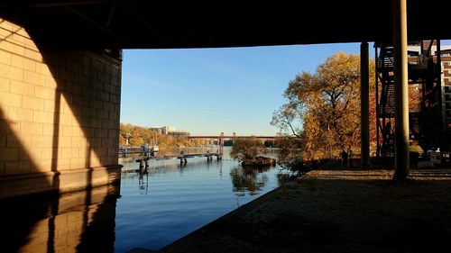 Bridge over river in city against clear sky