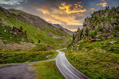 Road amidst green landscape against sky