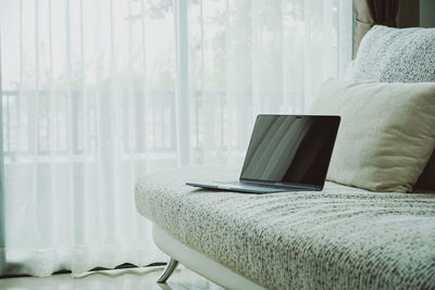 Tilt image of laptop on bed at home