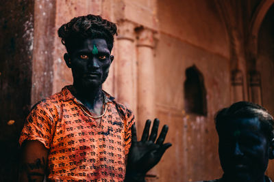 Portrait of man standing against wall