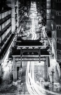 High angle view of illuminated street amidst buildings at night