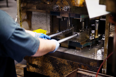 Cropped image of woman working on machinery in factory