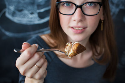 Portrait of woman holding sweet food at cafe