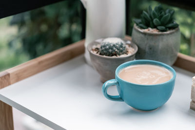 High angle view of coffee and potted plant on table