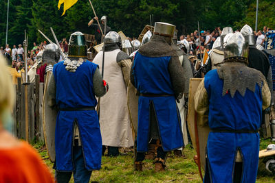 Rear view of people standing on field