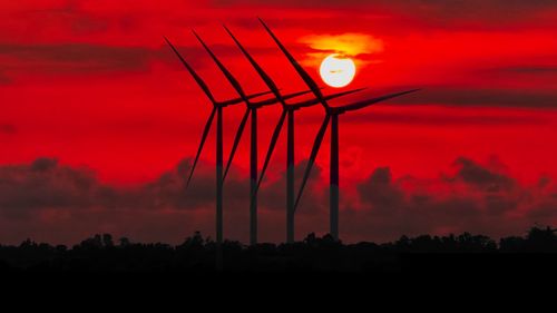 Low angle view of windmills during sunset