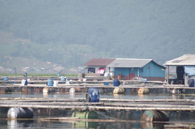 Houses by river and buildings against mountains