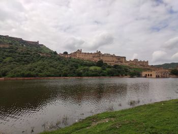 Lake by buildings against sky