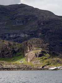 Scenic view of landscape by sea against sky