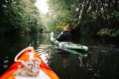 Man and boat in lake against trees