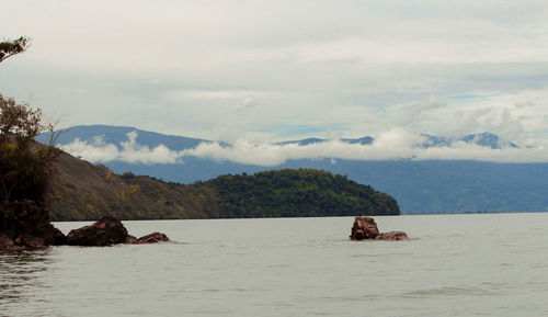 Scenic view of sea and mountains against sky