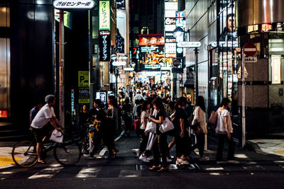 People walking on city street at night