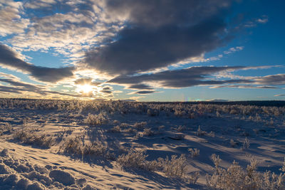 Aerial view of snowcapped landscape against sky during sunset