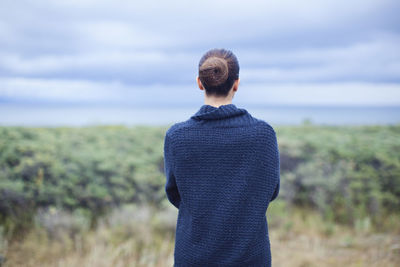 Rear view of woman standing against sky