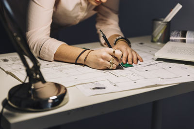 Midsection of architect working at desk in office