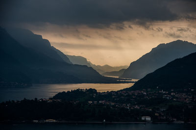 Scenic view of sea and mountains against sky at sunset