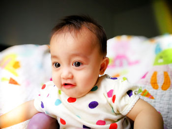 Portrait of cute baby girl on bed