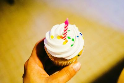 Close-up of hand holding birthday cake