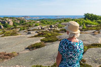 Rear view of senior woman looking at sea against sky