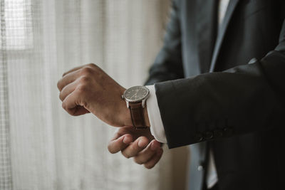 Midsection of businessman adjusting sleeve