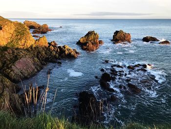 Rocks on beach against sky