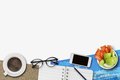 Directly above shot of eyeglasses on table against white background