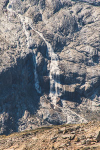 Frozen waterfall against rock formation