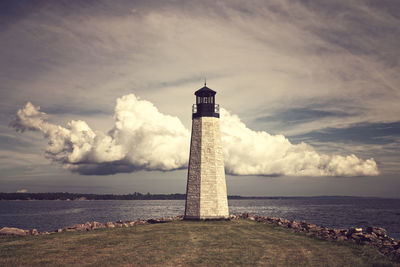 Lighthouse by sea against sky