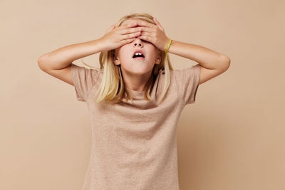 Portrait of woman standing against pink background