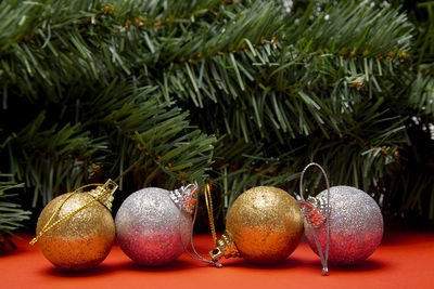 Close-up of christmas ornaments on red table