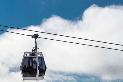 Low angle view of overhead cable car against sky