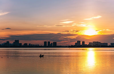 Silhouette buildings against sky during sunset