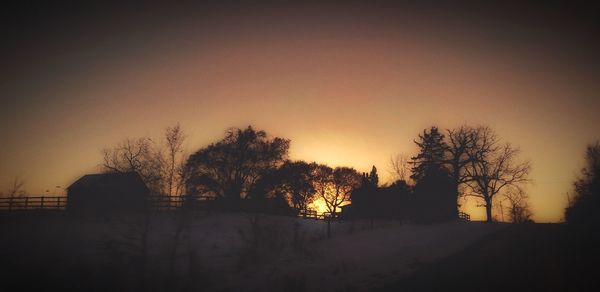 Silhouette trees against sky during sunset