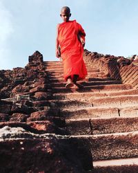 Low angle view of monk moving down on steps