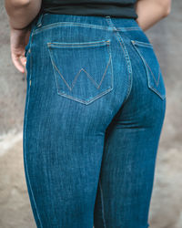 Rear view of woman standing with blue jeans