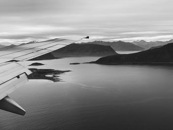 Flying over the norwegian coast, above the fjords and the mountain ranges, black and white 