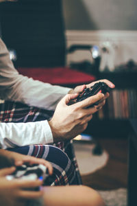 Close-up of father playing video games with is son at home.