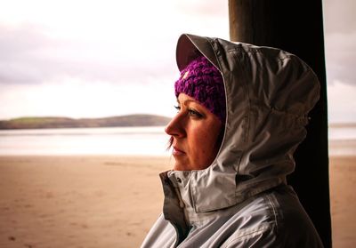 Close-up of woman standing at beach against sky